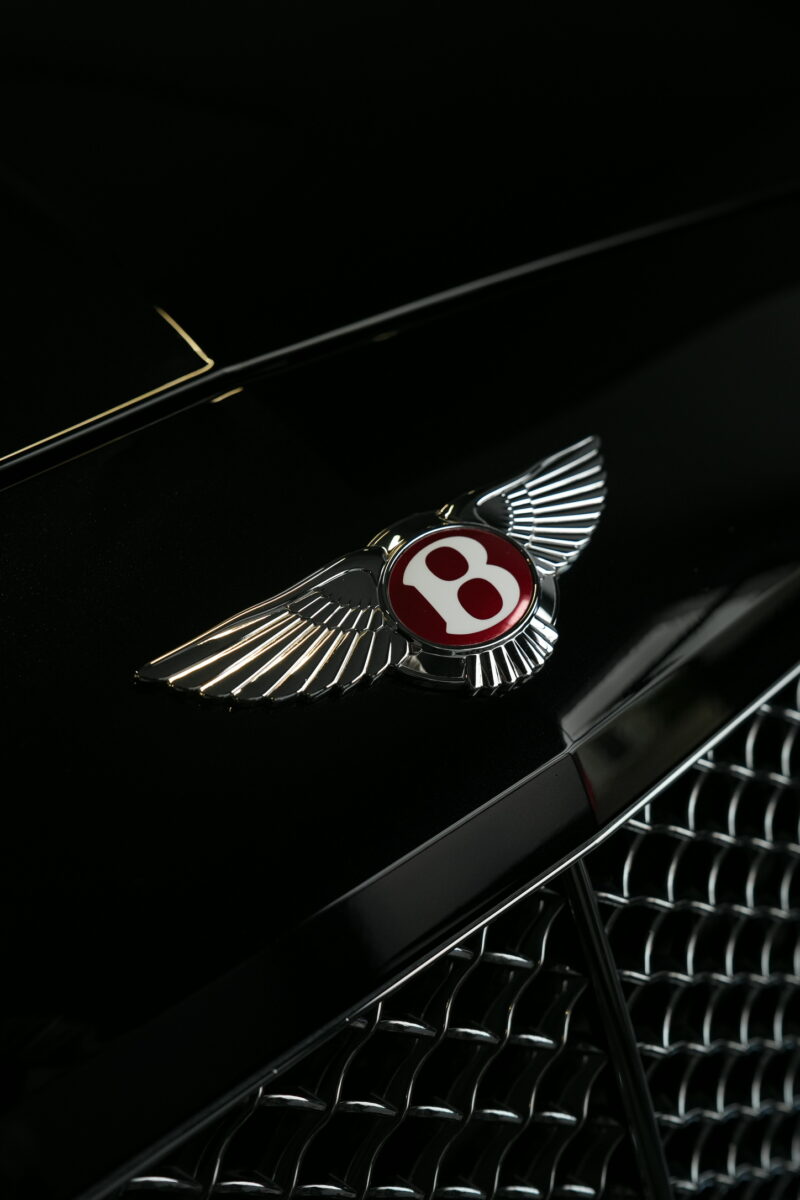 Bentley front grille and emblem detail captured in a dark premium automotive style
