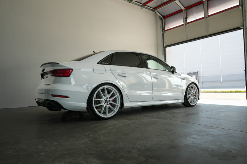 Audi RS3 side view photographed indoors with clean automotive lighting