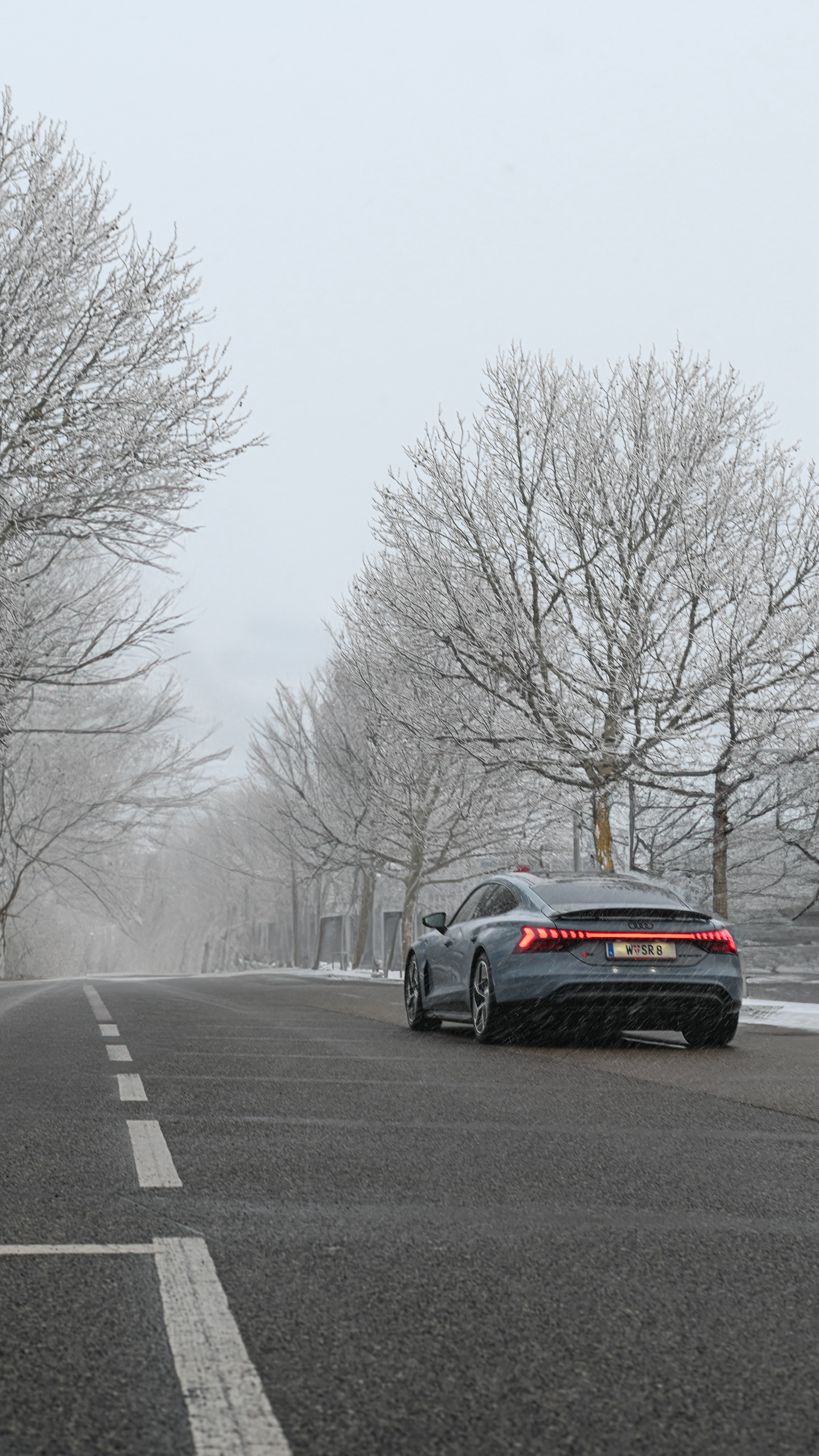 Audi RS e-tron GT driving on a snowy road captured in a winter automotive scene
